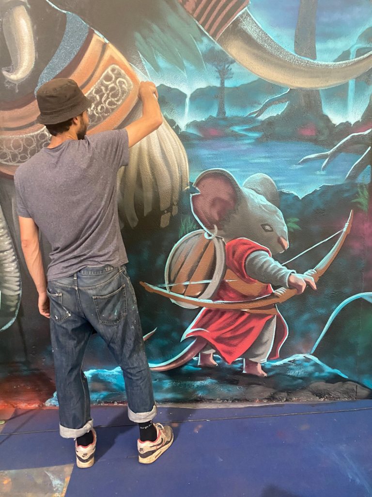 Un artiste peint un détail de la fresque de l’éléphant à Canohès