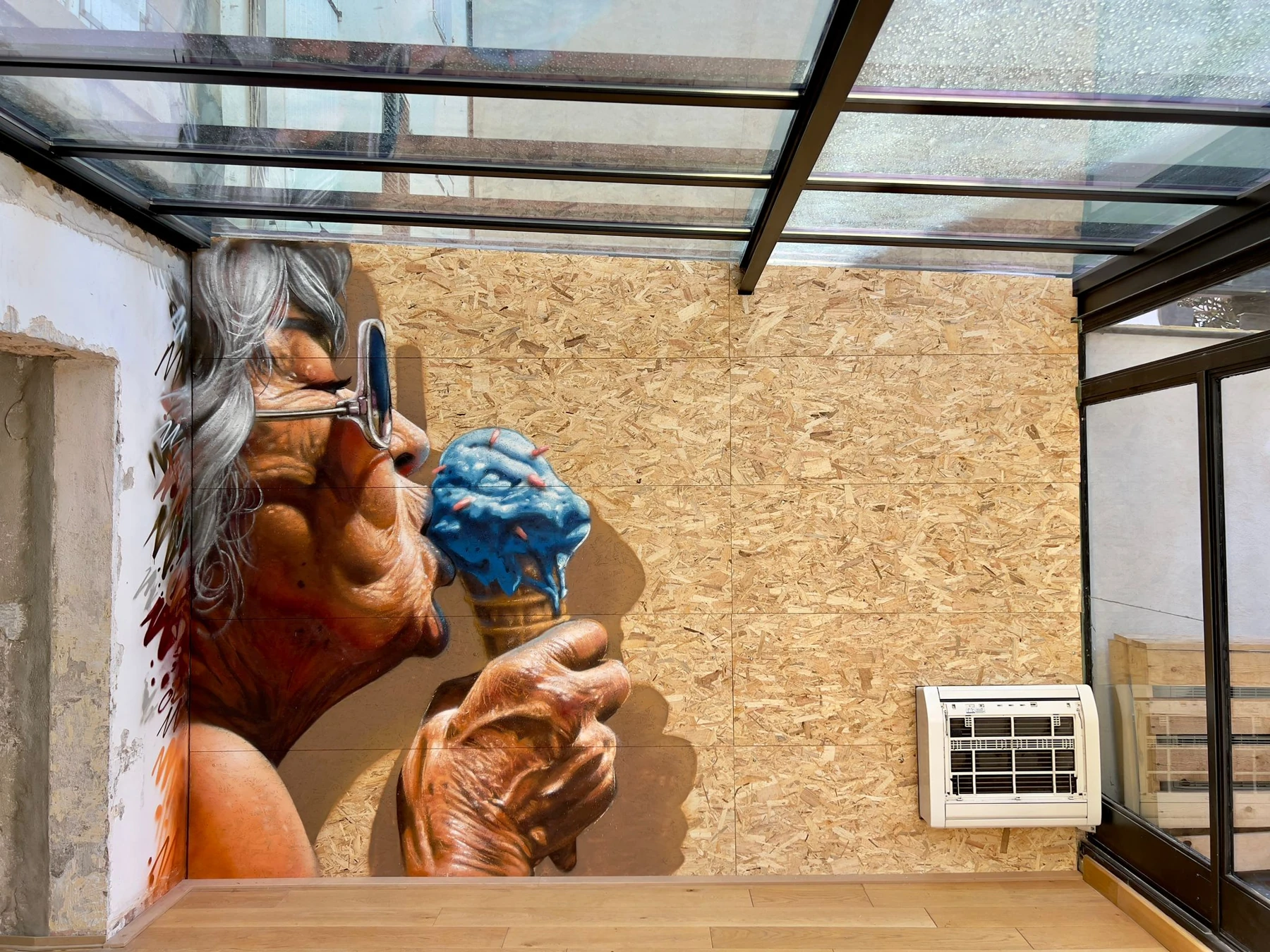 Artwork by Braga Last One: grey-haired figure holding a blue ice cream, painted in a wall corner