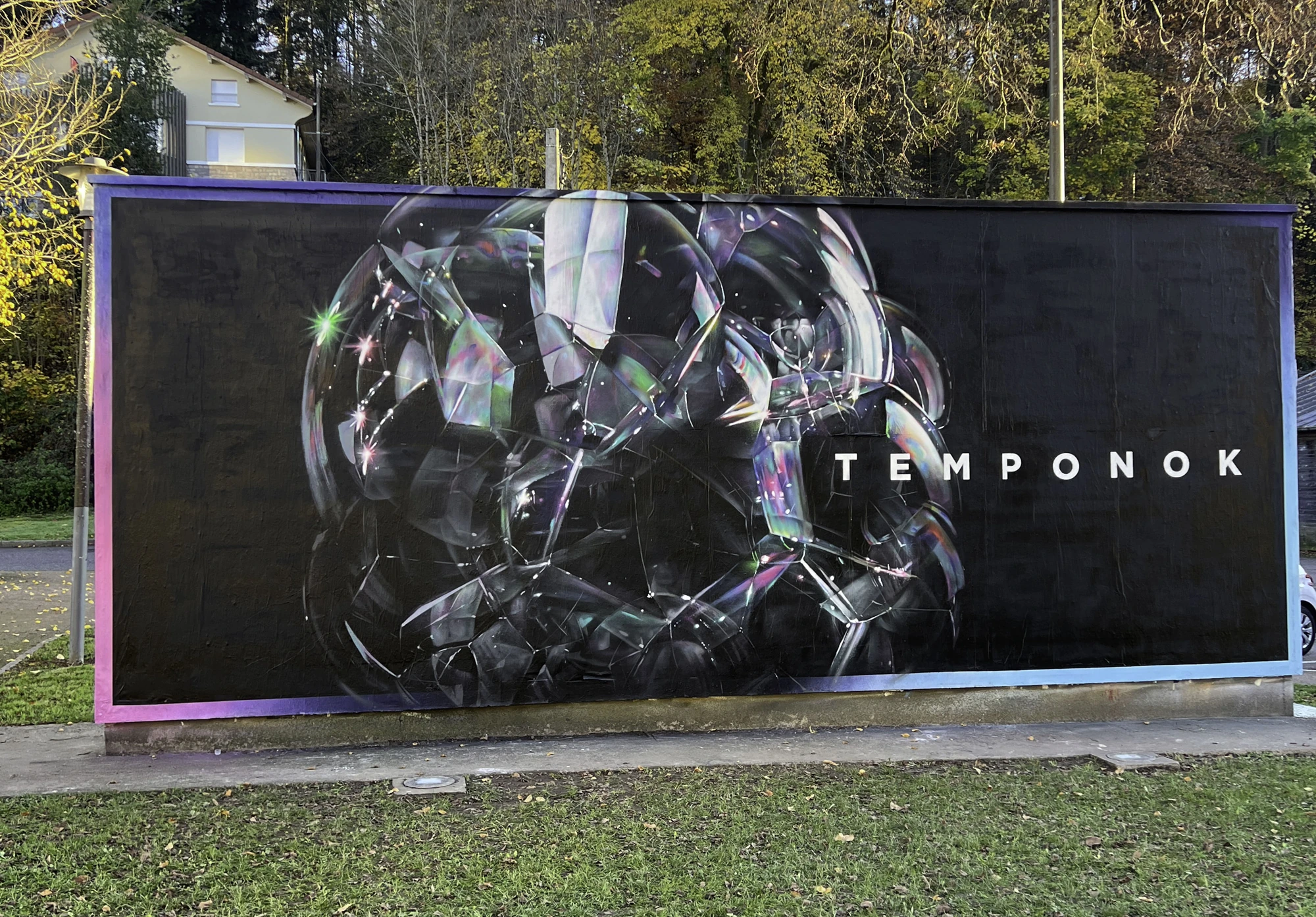 Mural by Temponok: chrome shapes with iridescent reflections on a black background